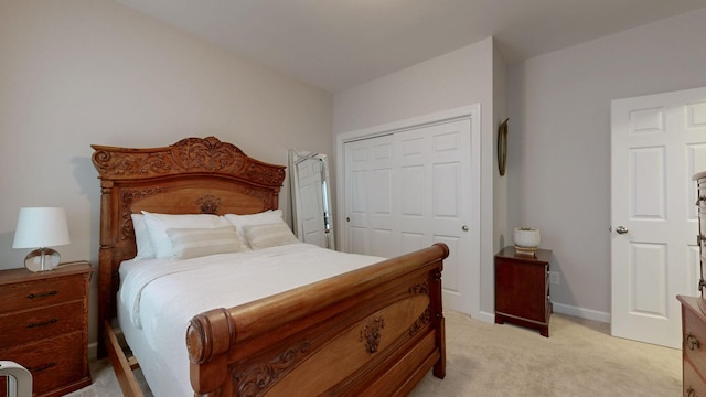 bedroom with a closet, light carpet, and baseboards