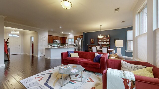 living room featuring visible vents, baseboards, ornamental molding, and dark wood-style floors