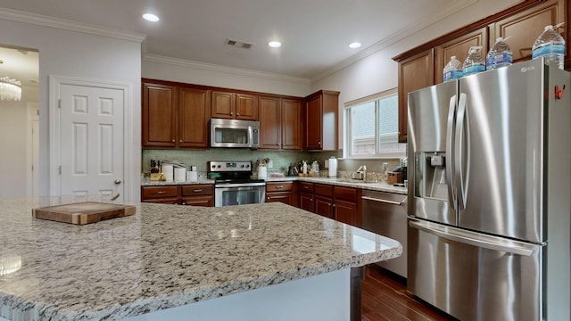 kitchen featuring dark wood-style flooring, visible vents, crown molding, decorative backsplash, and appliances with stainless steel finishes