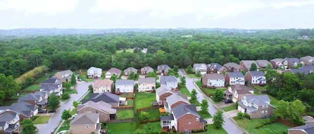 drone / aerial view featuring a forest view and a residential view