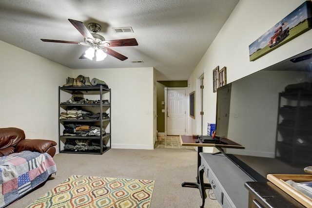 office area featuring a ceiling fan, a textured ceiling, visible vents, and carpet