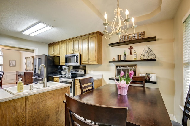 kitchen with light countertops, stainless steel appliances, a sink, and a chandelier