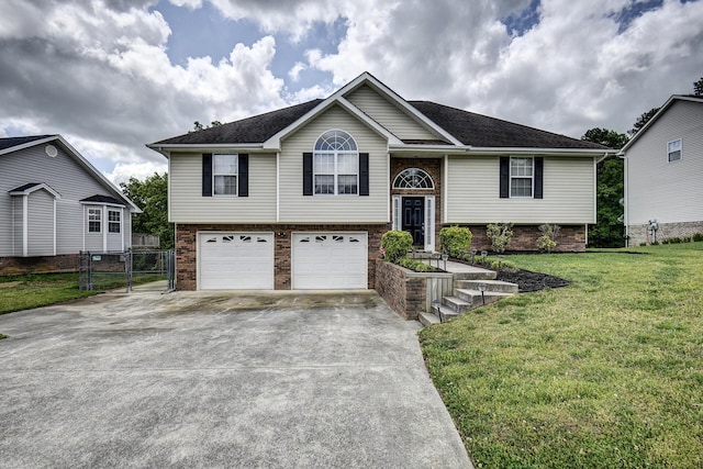 bi-level home featuring a garage, brick siding, fence, a front lawn, and concrete driveway