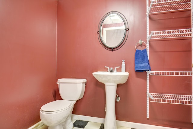 bathroom with toilet and baseboards