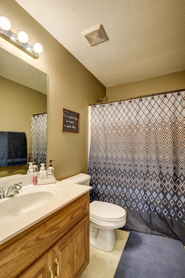 bathroom featuring vanity, toilet, a textured ceiling, and visible vents