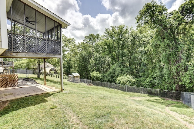 view of yard with a sunroom, a fenced backyard, ceiling fan, and a patio area