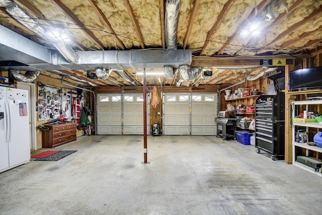 garage featuring white refrigerator with ice dispenser