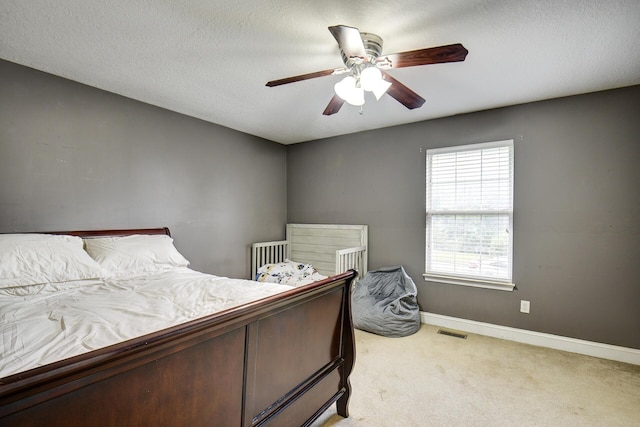 carpeted bedroom featuring visible vents, a ceiling fan, and baseboards