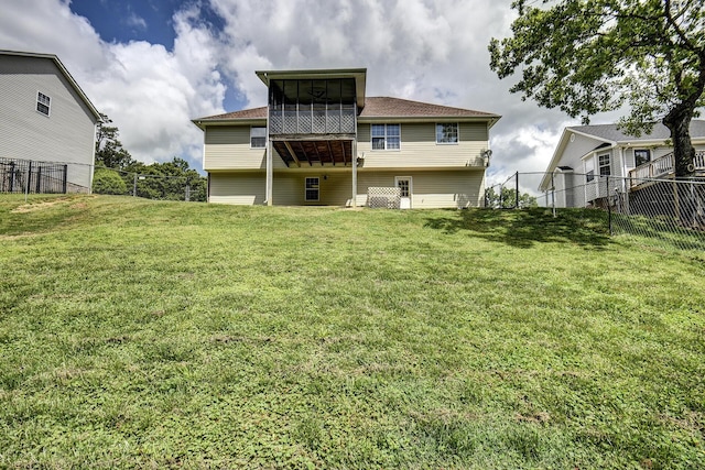 back of property featuring a lawn, a fenced backyard, and a sunroom
