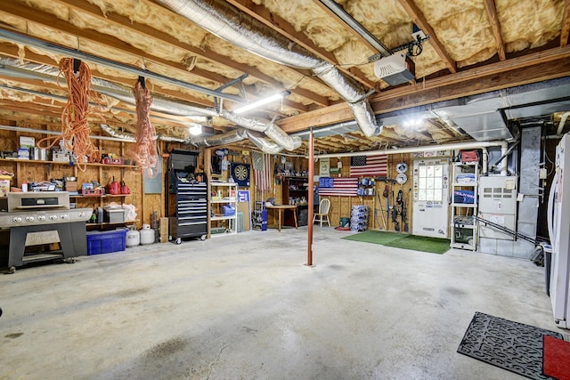 below grade area featuring freestanding refrigerator and a workshop area