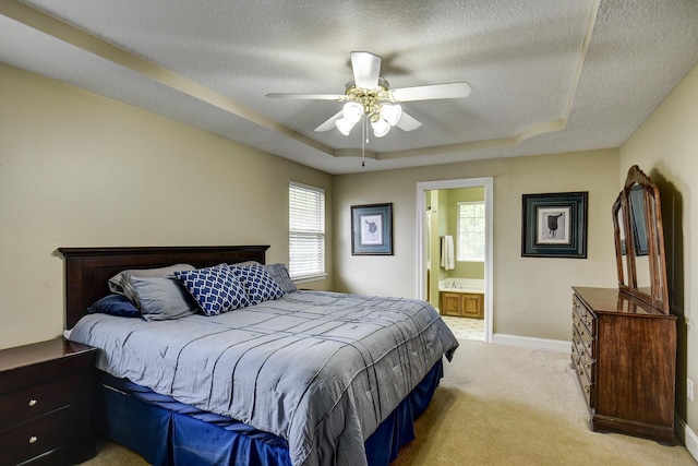 bedroom featuring baseboards, a tray ceiling, a textured ceiling, and light colored carpet