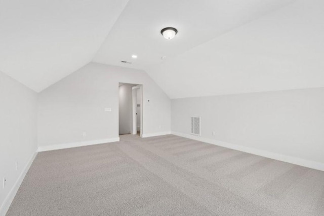 bonus room with carpet floors, baseboards, vaulted ceiling, and visible vents