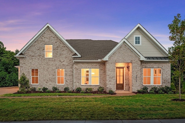 craftsman-style home with brick siding and a front lawn