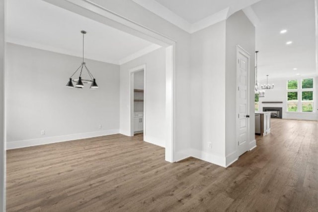interior space with an inviting chandelier, wood finished floors, a fireplace, baseboards, and recessed lighting