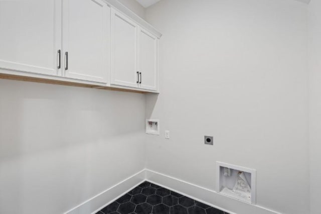 laundry room featuring washer hookup, hookup for an electric dryer, cabinet space, dark tile patterned flooring, and baseboards