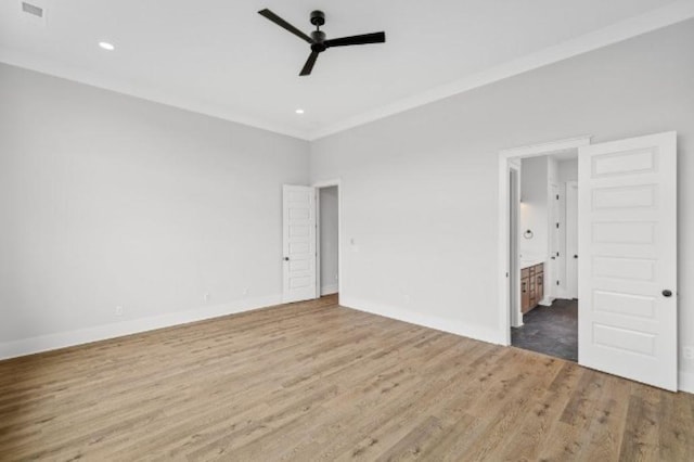 unfurnished bedroom featuring baseboards, wood finished floors, and connected bathroom