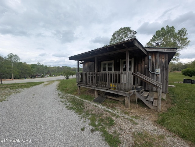 view of side of home with gravel driveway