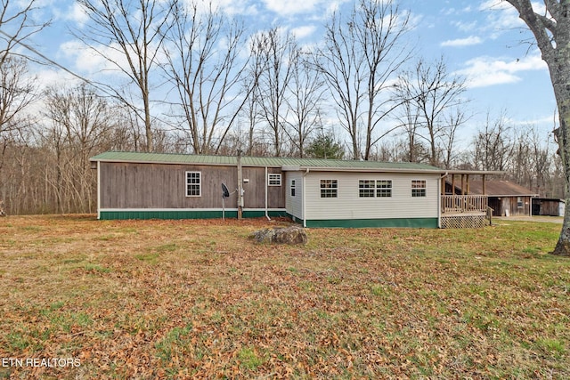 manufactured / mobile home featuring metal roof and a front lawn