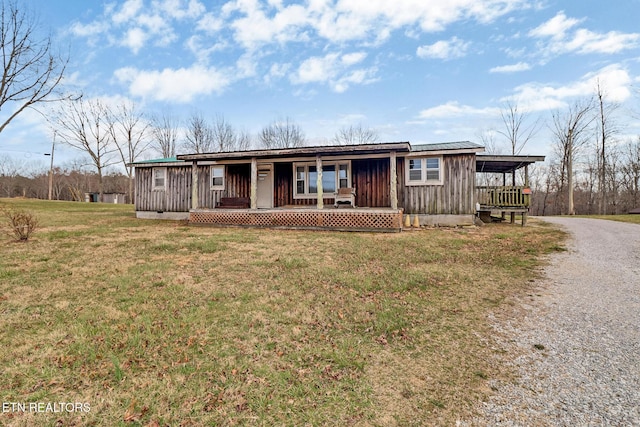 view of front of property featuring board and batten siding, a porch, driveway, and a front yard