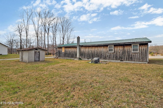 exterior space with an outdoor structure, board and batten siding, a lawn, and a storage shed