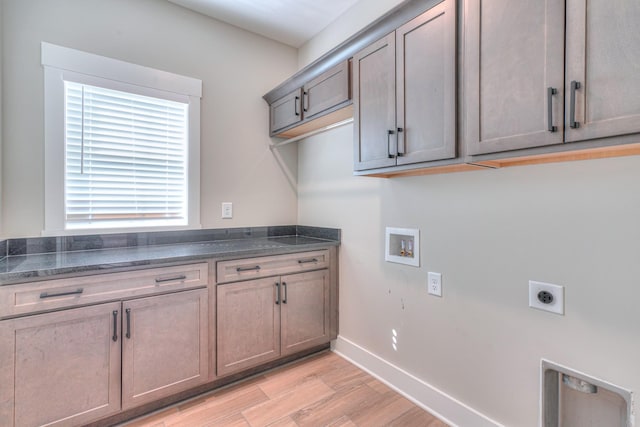 clothes washing area with washer hookup, hookup for an electric dryer, cabinet space, baseboards, and light wood-style flooring
