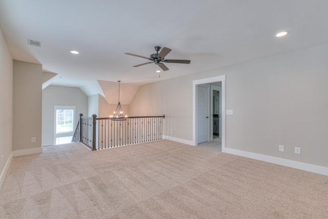 empty room featuring light carpet, ceiling fan with notable chandelier, recessed lighting, and visible vents
