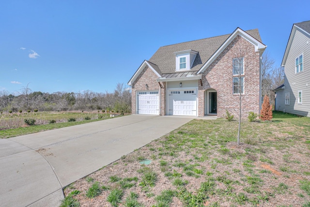 traditional-style house featuring brick siding, metal roof, driveway, and a standing seam roof