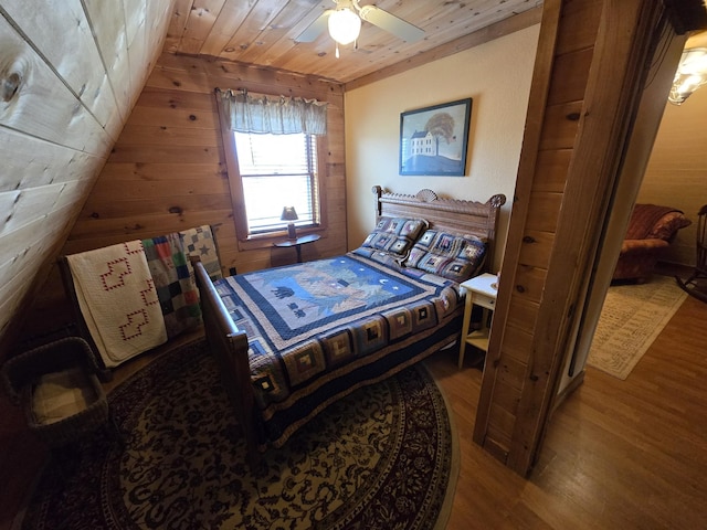 bedroom with wood walls, wood ceiling, lofted ceiling, and wood finished floors