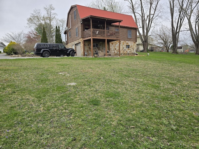 back of property with a gambrel roof, stone siding, a wooden deck, a yard, and metal roof