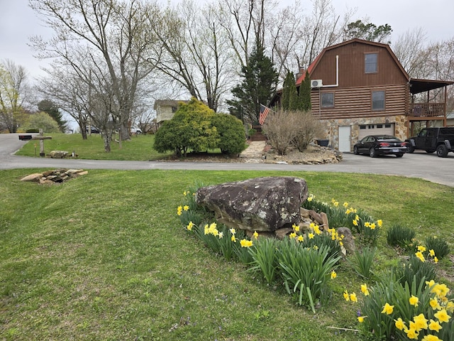 view of yard featuring an attached garage and driveway