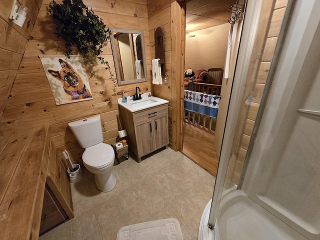 full bath with vanity, toilet, wooden walls, tile patterned floors, and a shower stall