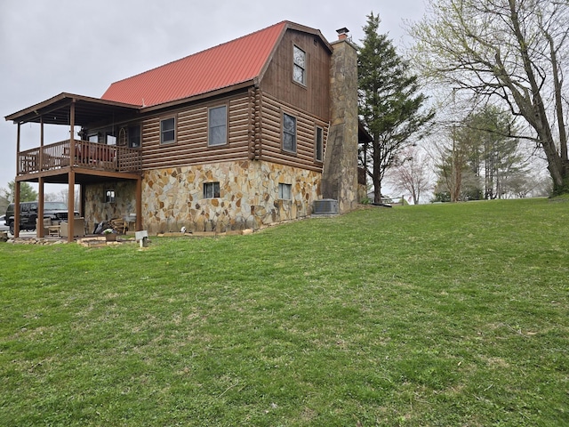 back of house featuring central AC, stone siding, log exterior, a chimney, and a lawn
