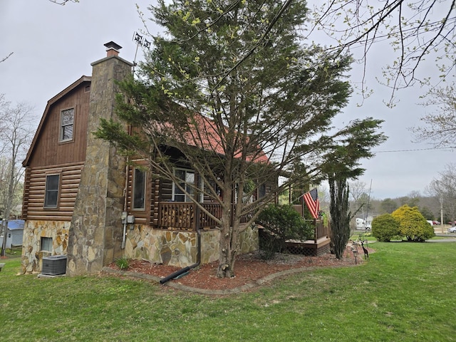 view of side of home featuring stone siding, a chimney, central AC unit, log exterior, and a yard