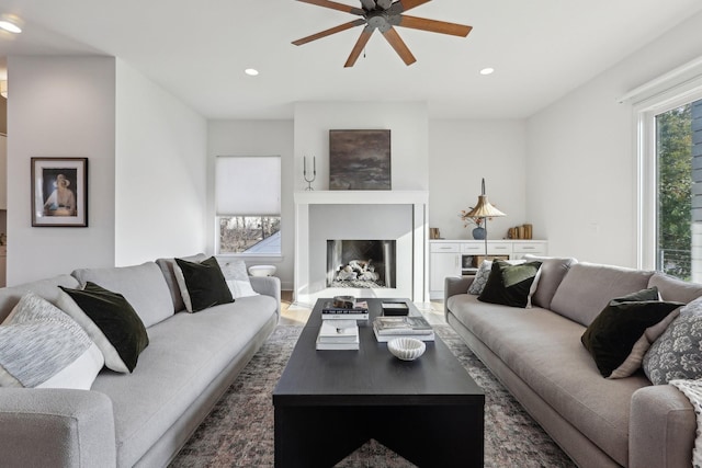 living room featuring recessed lighting, ceiling fan, wood finished floors, and a fireplace