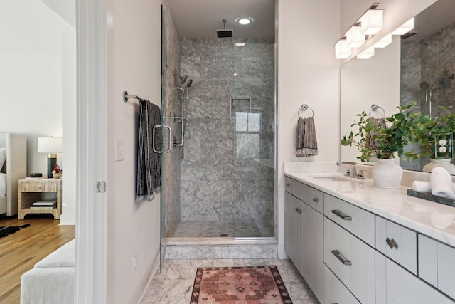 full bathroom featuring a stall shower, vanity, baseboards, marble finish floor, and ensuite bath