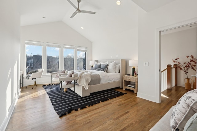 bedroom featuring baseboards, a ceiling fan, wood finished floors, and high vaulted ceiling