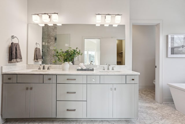 full bathroom featuring a sink, toilet, double vanity, and marble finish floor
