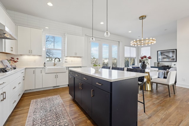 kitchen with a sink, a kitchen breakfast bar, a kitchen island, and plenty of natural light