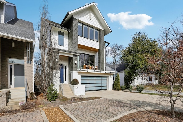 modern home with an attached garage, driveway, and a balcony