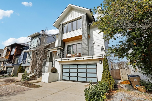 view of front of house with driveway, a balcony, and a garage