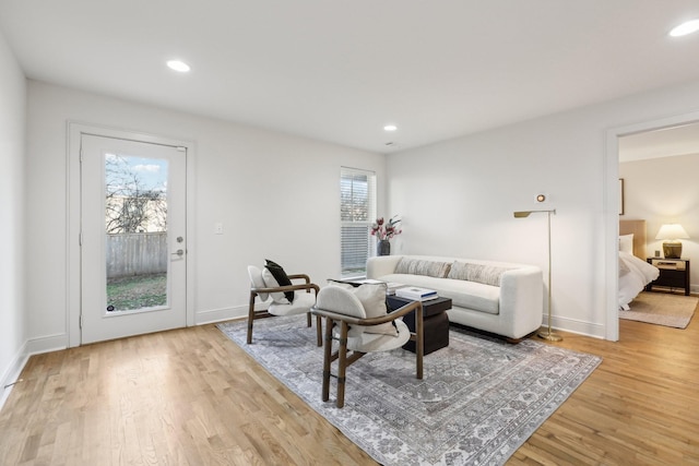 living room with light wood-type flooring, recessed lighting, and baseboards