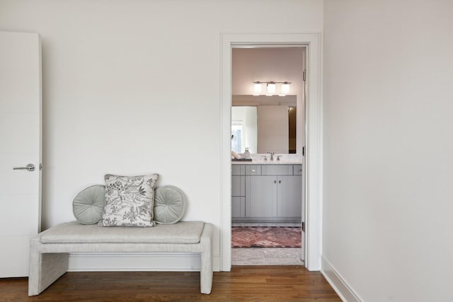 living area with baseboards and wood finished floors