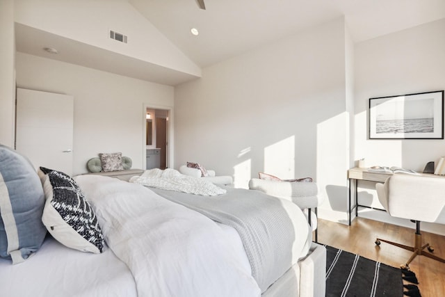 bedroom featuring visible vents, wood finished floors, and high vaulted ceiling