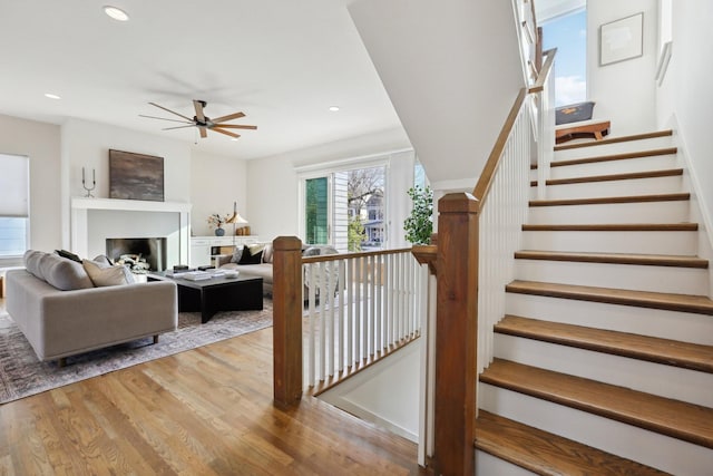 living room with a ceiling fan, recessed lighting, and wood finished floors
