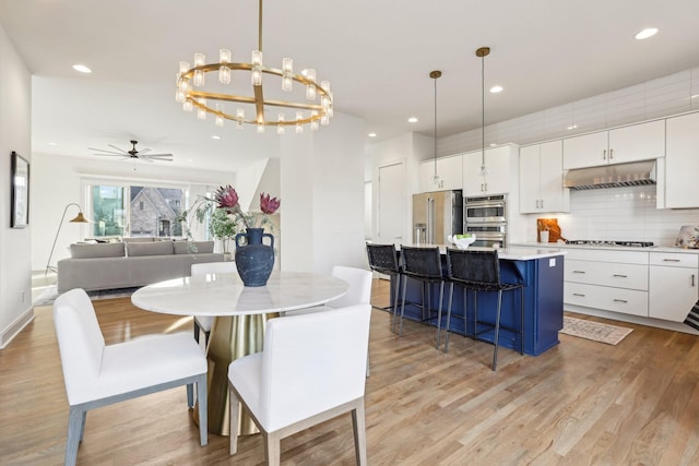 dining room featuring recessed lighting, light wood finished floors, and ceiling fan with notable chandelier