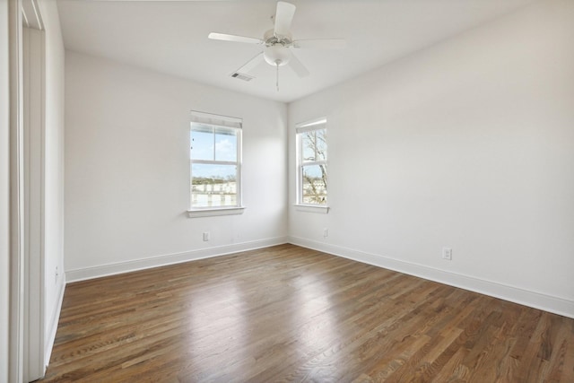 unfurnished room featuring baseboards, ceiling fan, wood finished floors, and visible vents