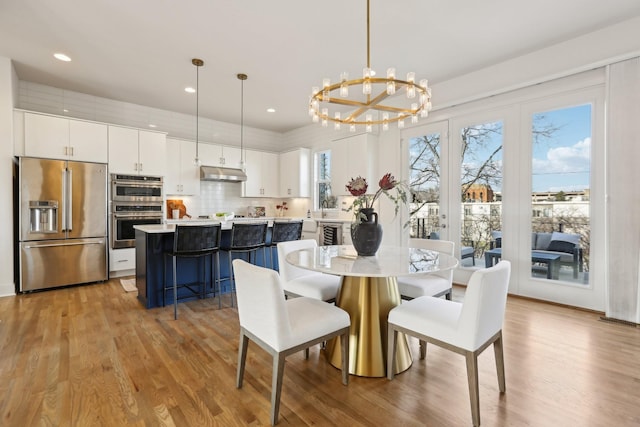 dining room featuring an inviting chandelier, recessed lighting, and light wood-style flooring