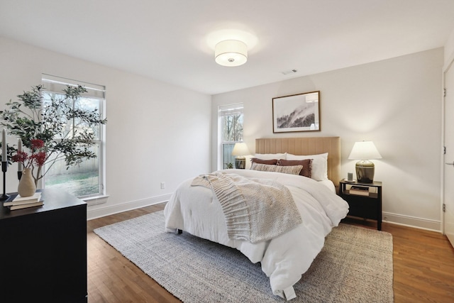 bedroom with baseboards and wood finished floors