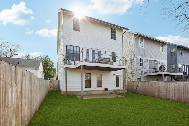 back of house with a fenced backyard, a gate, entry steps, a balcony, and a yard