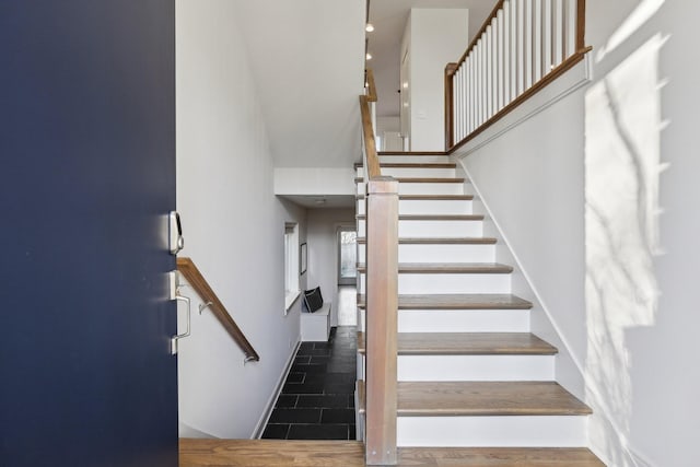 stairs with baseboards, a high ceiling, and recessed lighting